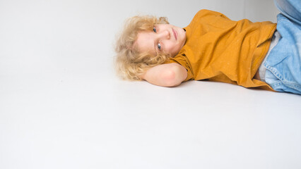 Young Boy Lying Down Casually in a Bright Studio Setting