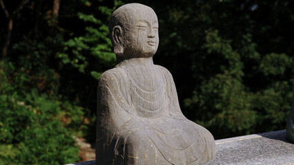 Religious artefact: a stone statuette of Buddha. Garden Sculptures. South Korea