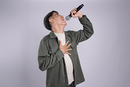 Stylist asian men singing songs with microphone, holding mic and dancing at karaoke isolated white background.