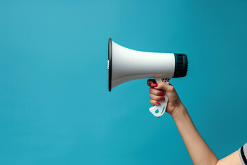 Hand Holding Megaphone Against Blue Background Concept