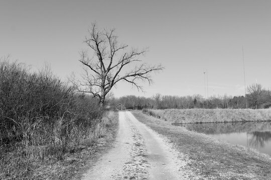 A black and white photo of the gravel road in the country.
