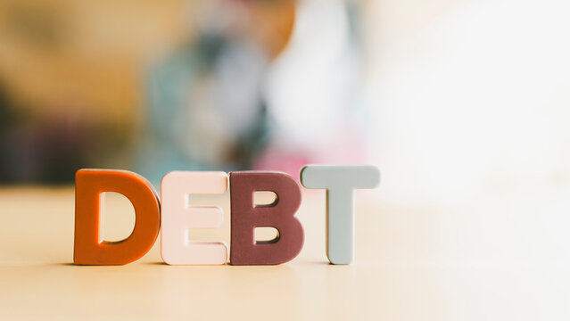 The letters of the word debt are placed on the table, the concept of the debt of the people, countries all over the world is increasing.