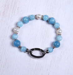 Aquamarine bracelet. Bracelet made of stones on hand from natural stone Aquamarine. Bracelet made of natural stones with an elastic band. Handmade jewelry bracelets on light modern background.