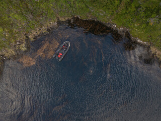 aerial view of rubber boat in the water next to an island