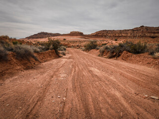 Sandy wash through red desert terrain with hills and sandstone features near Moab Utah