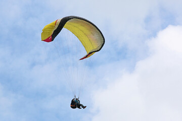 Tandem Paraglider flying in a blue sky	