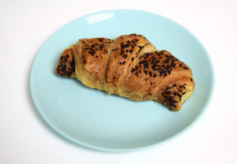 Handmade croissant with chocolate on blue plate on white background 