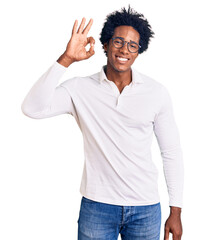 Handsome african american man with afro hair wearing casual clothes and glasses smiling positive doing ok sign with hand and fingers. successful expression.