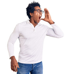 Handsome african american man with afro hair wearing casual clothes and glasses shouting and...