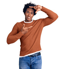 Handsome african american man with afro hair wearing casual clothes smiling making frame with hands...