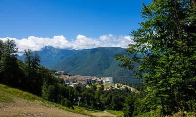 Obraz premium Beautiful panoramic landscape - view of Glade 960 with modern luxury hotels among the green mountains on a sunny summer day in Russia