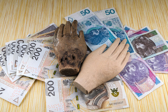 Polish money covered with a wooden hand.