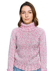 Young caucasian girl wearing wool winter sweater relaxed with serious expression on face. simple...