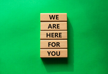 Help symbol. Wooden blocks with words We are here for you. Beautiful green background. Business and We are here for you concept. Copy space.