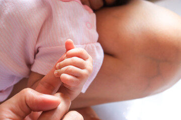 baby holding mother finger