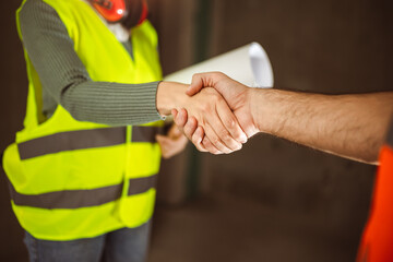 Contractor. construction worker team hands shaking after plan project contract  at construction site, contractor, engineering, partnership, construction concept - 780826723
