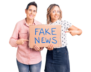 Couple of women holding fake news banner smiling happy pointing with hand and finger