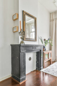 Vintage fireplace with ornate mirror in a bright room