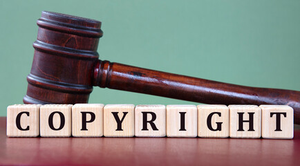 COPYRIGHT - word on wooden cubes on background of judge's gavel
