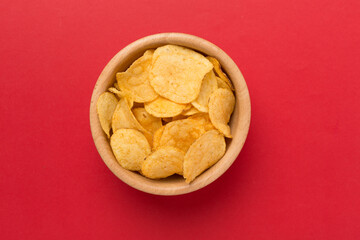 Appetizing potato chips on color background, top view