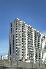 Fototapeta na wymiar New grey high-rise building in a residential neighborhood.