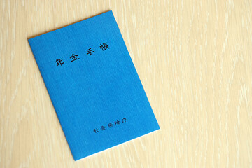 Japanese pension insurance booklet on table. Blue pension book for japan pensioners close up