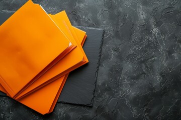 Top view of orange folders on black table room for text - obrazy, fototapety, plakaty