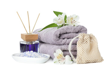 Spa composition. Towels, aromatherapy products, sea salt and beautiful flowers on white background