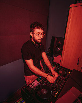 Concentrated DJ mixing music at a club setup