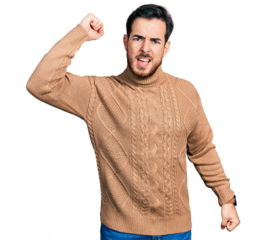 Young hispanic man wearing casual clothes angry and mad raising fist frustrated and furious while shouting with anger. rage and aggressive concept.