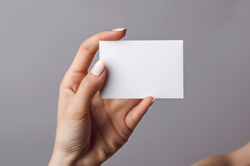 Close-up of Hand Holding a Blank White Card with Neutral Background