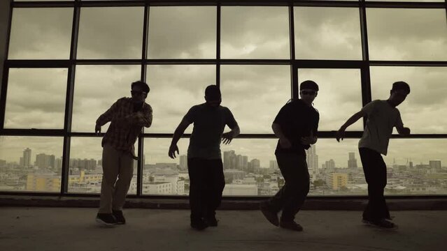 Silhouette shot of skilled choreographer group dancing together with sky scrapper, cityscape background. Young hipster team dancing performance. Sepia filter. Shadow. Outdoor sport 2024. hiphop.