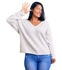 Hispanic woman with long hair wearing casual clothes showing and pointing up with fingers number...