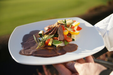 Leckeres Roastbeef mit Salat auf einem Teller vom Kellner präsentiert