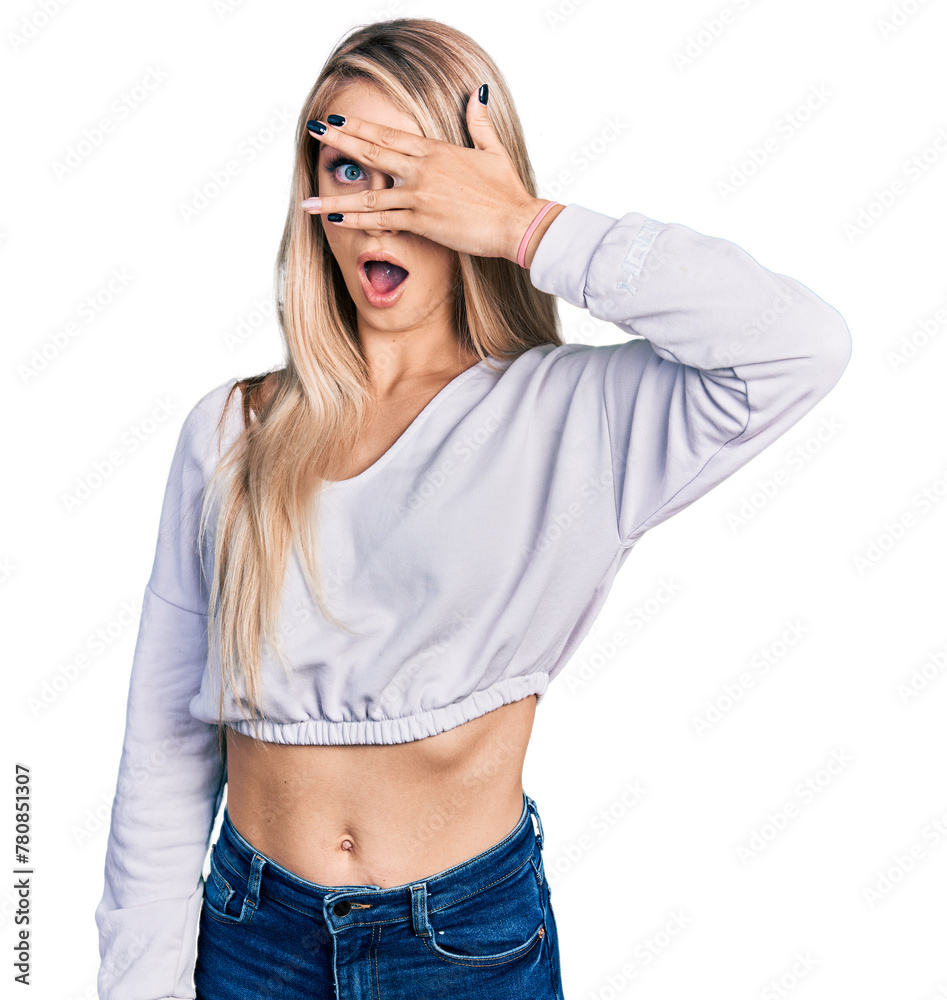 Poster beautiful young blonde woman wearing casual white sweater peeking in shock covering face and eyes wi