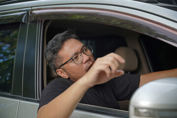 An irritated young man driving a vehicle is expressing his road rage.