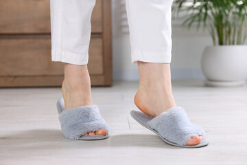 Woman in grey soft slippers at home, closeup - obrazy, fototapety, plakaty