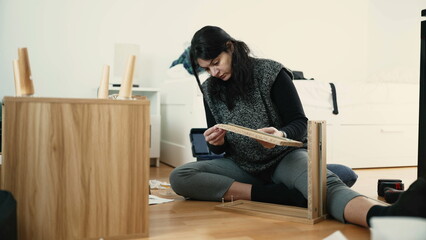 Young Woman Assembling Wooden Nightstand, Demonstrating Do-It-Yourself Expertise in Home Decor,...
