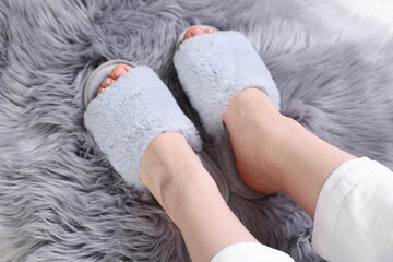 Woman in grey soft slippers at home, closeup
