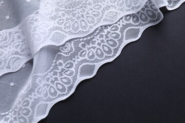 White lace on black background, top view. Space for text