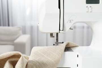 Fototapeta premium White sewing machine and fabric indoors, closeup