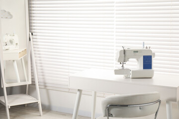 Sewing machine on white desk in workshop