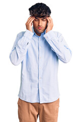 Young hispanic man wearing casual shirt with hand on head for pain in head because stress. suffering migraine.