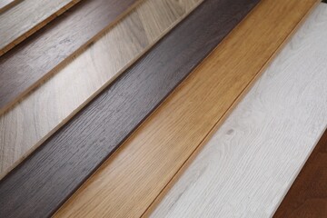 Different samples of wooden flooring as background, flat lay