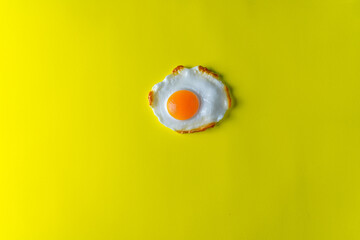 Fried egg on a yellow background. Top view with space for text. Flat lay.