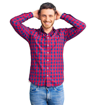 Handsome young man with bear wearing casual shirt relaxing and stretching, arms and hands behind head and neck smiling happy
