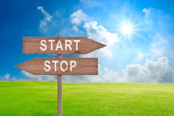 Red and green street signs with blue sky with words Stop and Start, Stop versus Start