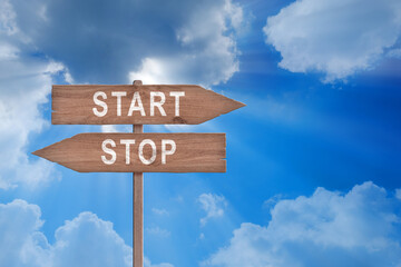 Red and green street signs with blue sky with words Stop and Start, Stop versus Start