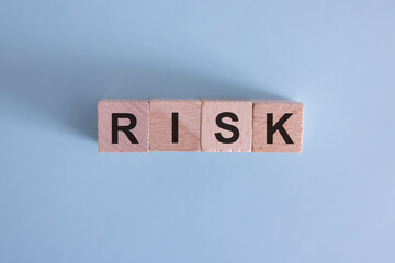 Wooden cubes with the word risk. Risk taking, risk management or assessment concept. Eliminate risk in business finance decisions.