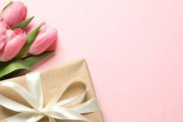 Happy Mother's Day. Beautiful tulips and gift box on pink background, flat lay. Space for text